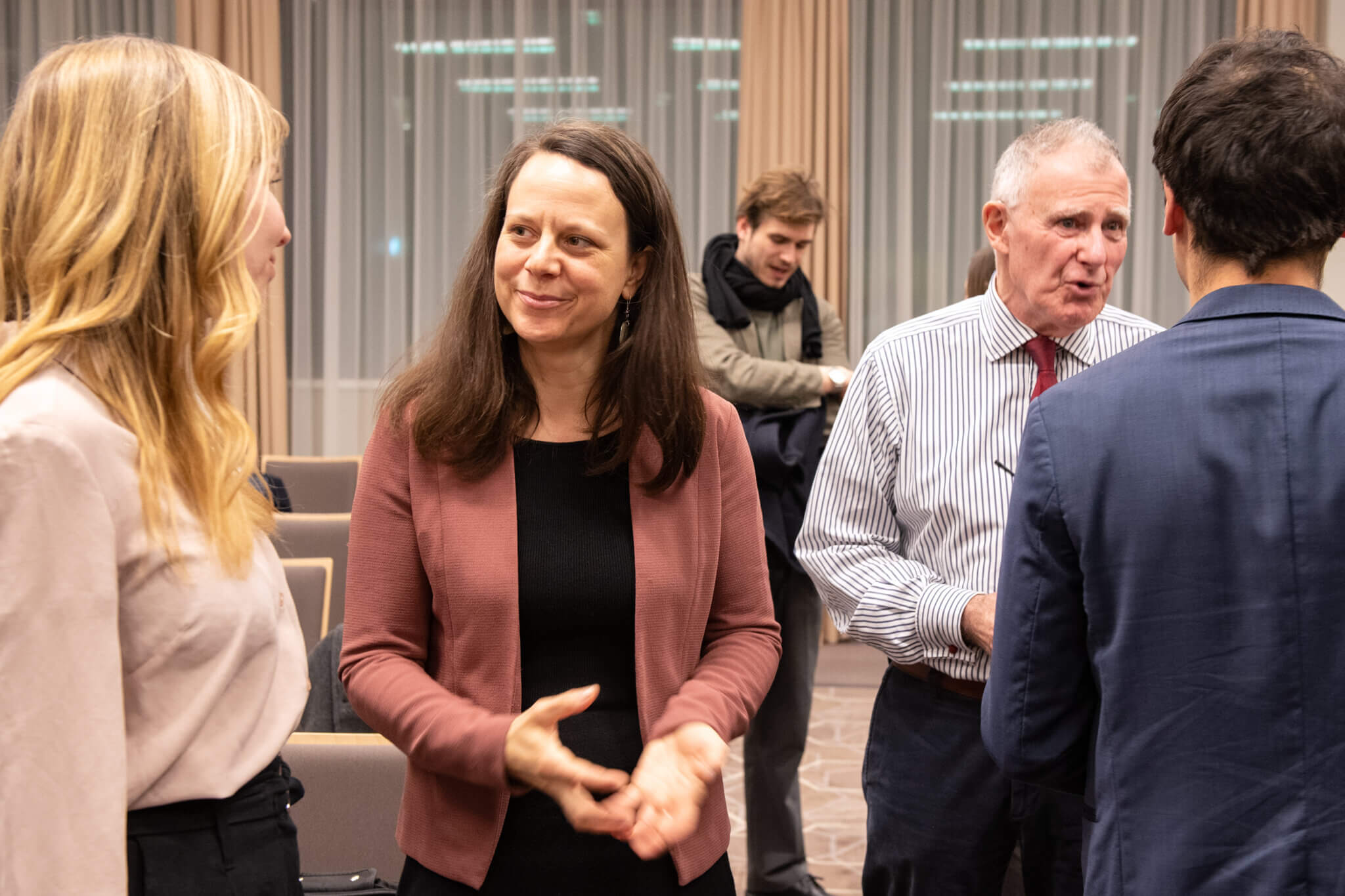 On the picture you can see two woman who are talking to each other. They both are wearing business-like clothes. They are listeners of a panel discussion around inclusive humanitarian action.