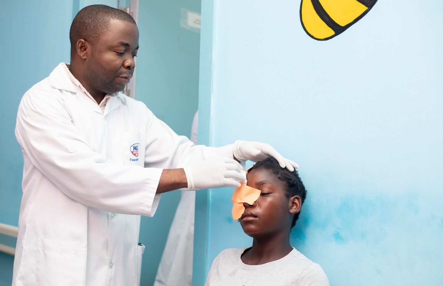Dr. Vasco da Gama entfernt einen Augenverband bei einem Kind in der Augenklinik in Quelimane, Mosambik.