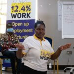 Das Bild zeigt Cony Adoch, Inklusionsexpertin bei Licht für die Welt. Sie hält einen Vortrag und trägt ein T-Shirt mit dem Logo der Initiative 