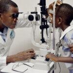 Dr. Abel Polaze aus Mosamik bei einer Augenuntersuchung an einem Burschen im Krankenhaus.