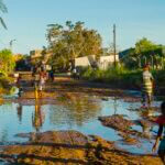 Erwachsene und Kinder gehen durch den Schlamm nach dem Zyklon in Mosambique