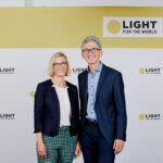 Gründer von Licht für die Welt Rupert Roniger und Geschäftsführerin von Licht für die Welt Österreich vor einer Logowand