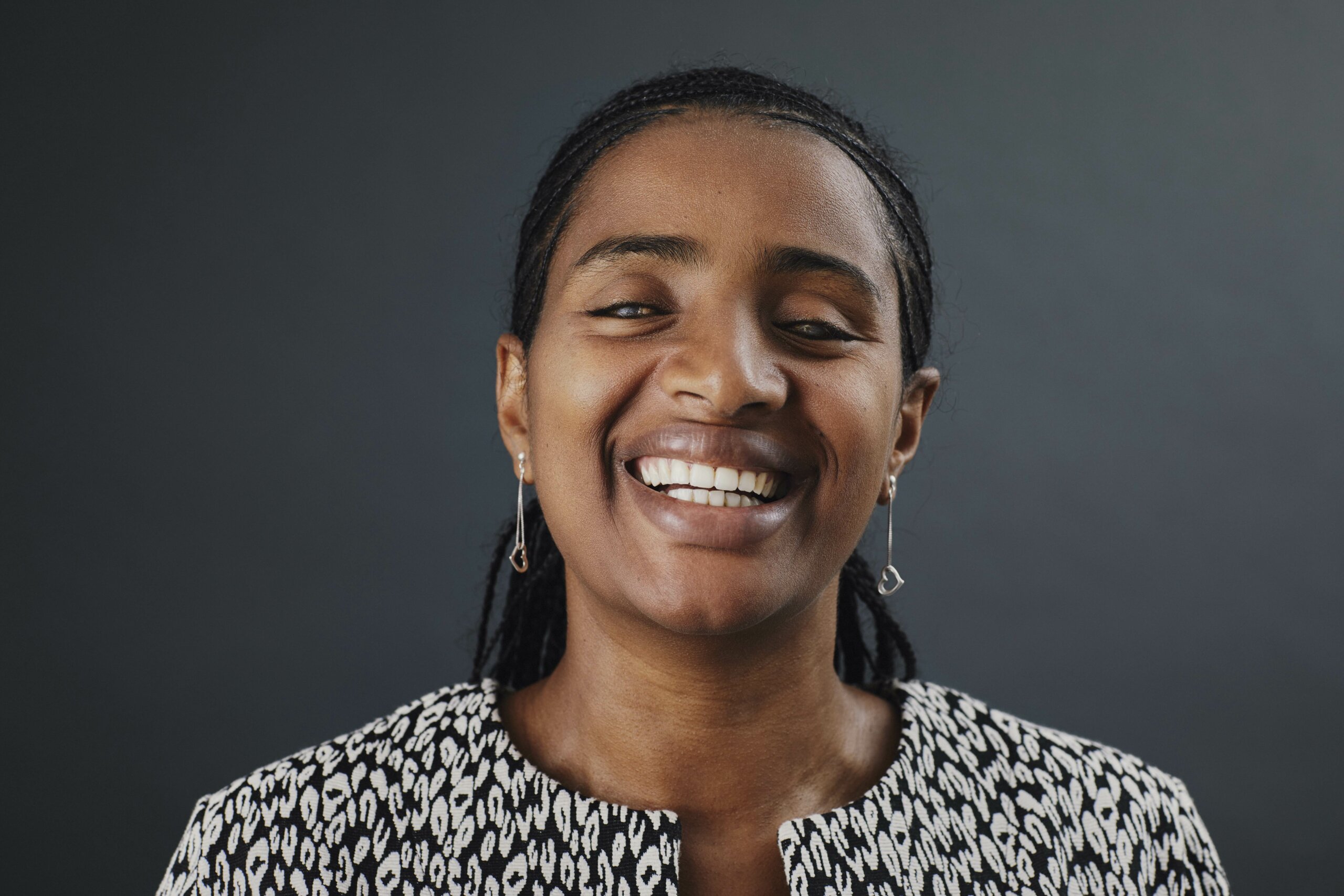 yetnebersh, a dark-skinned woman with black hair, in a white-black jacket smiles into the camera