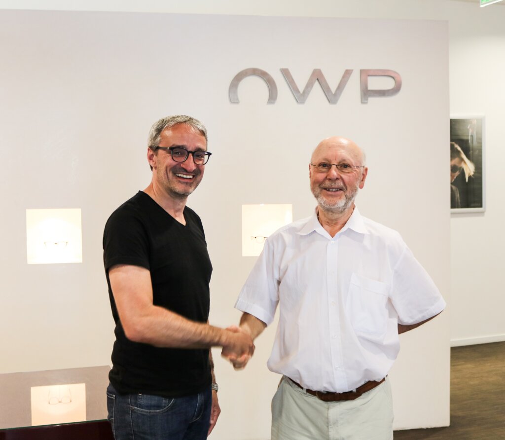 Werner Paletschek, CEO of OWP, and Dr. Johann Dillinger, former L-DE board member and ophtalmologist shaking hands and smiling in OWP’s headquarters in Passau