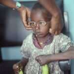 Ein Mädchen, das von Dr. Mary Asiyo-Vogel in Garissa, Kenia, augenmedizinisch untersucht wird und für die unbekannte Prozedur eine kleine Ermutigung bekam.