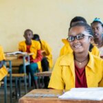 Nigest sitzt glücklich in ihrer Klasse, nachdem sie eine Brille von Licht für die Welt erhalten hat.