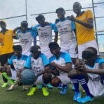Zu sehen ist die Fußballmannschaft des blinden Fußballvereins im Südsudan. Die Spieler tragen Augenbinden und einer hält den Spielball. Simon, der Trainer, ist ebenfalls auf dem Bild.