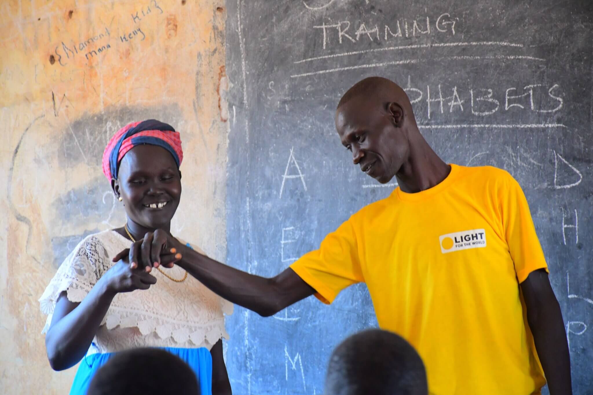 Ein Gebärdensprache-Trainer unterrichtet eine Lehrerin im Südsudan in Gebärdensprache.