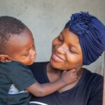 Die junge Mutter Nadja aus Mosambik hält ihren kleinen Sohn Ainyr im Arm und lächelt ihn glücklich an. Endlich kann er sehen und hat eine selbstständige Zukunft vor sich.