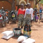 Image of two girls with food kits received as part of the emergency education project in Kossi.