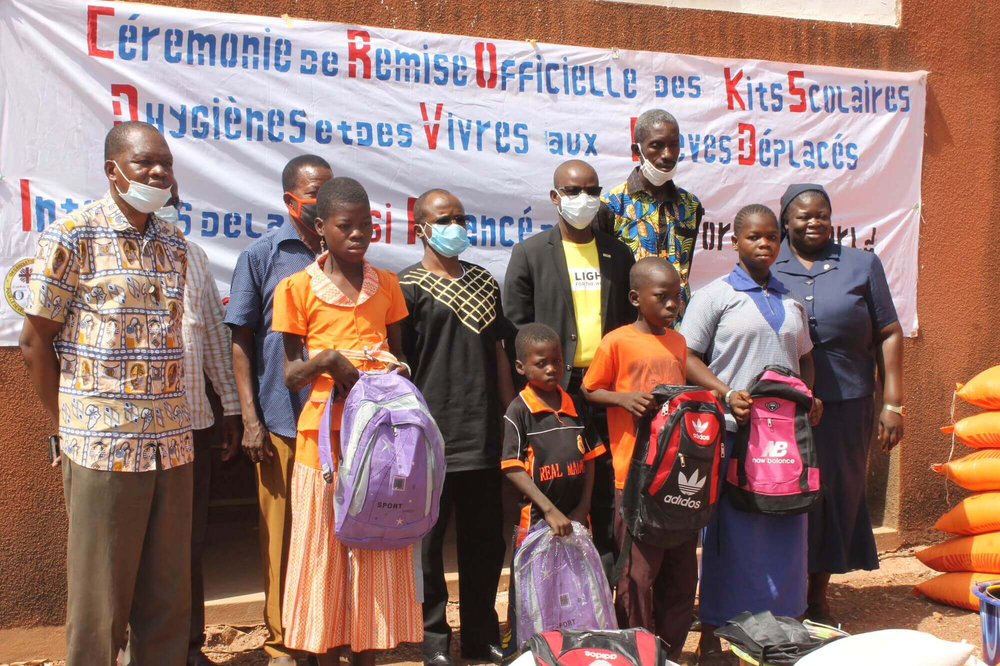 Image of school children receiving food kits and school supplies.