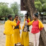 Nigest Uche aus Äthiopien spielt mit ihren Schulfreundinnen im Hof der Schule. Drei der vier Mädchen tragen die Schuluniform - eine gelbe Bluse und einen gelben langen Rock.