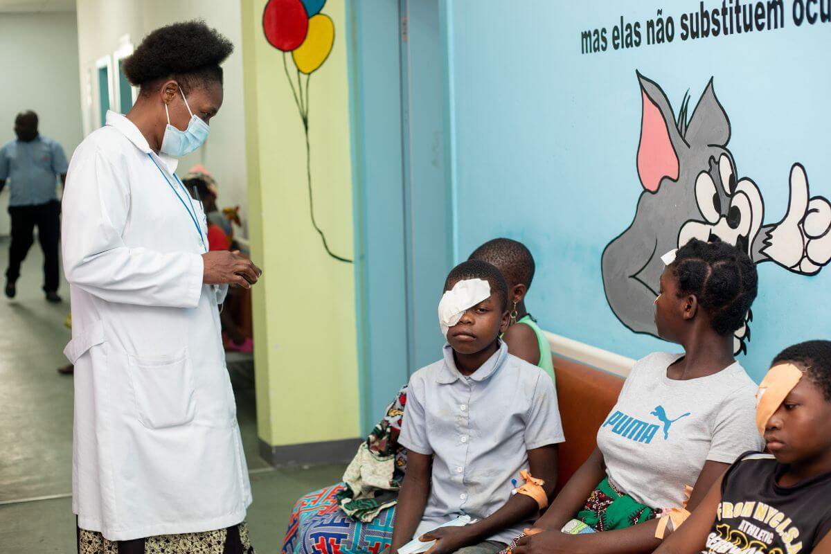 Ministro sitzt mit einem Verband über seinem Auge nach der Operation neben anderen Patient*innen im Krankenhaus