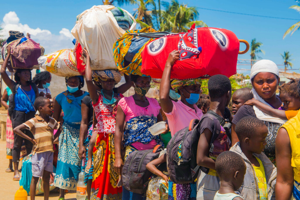 Mozambican children and adults are fleeing from the cyclone destroyed areas, some of them wearing masks are carrying everything they could rescue on their heads.
