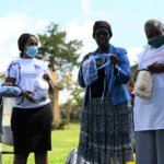 4 Kenyan women show the protective masks they produced. the masks have a transparent part over the mouth to help deaf and hard of hearing people with communication.