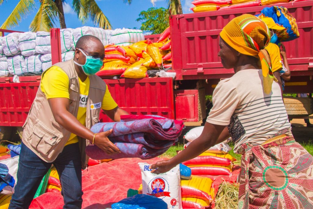 Pracovník Světla pro svět dává přikrývky a jídlo ženě poté, co Mozambik zpustošil cyklon Eloise.