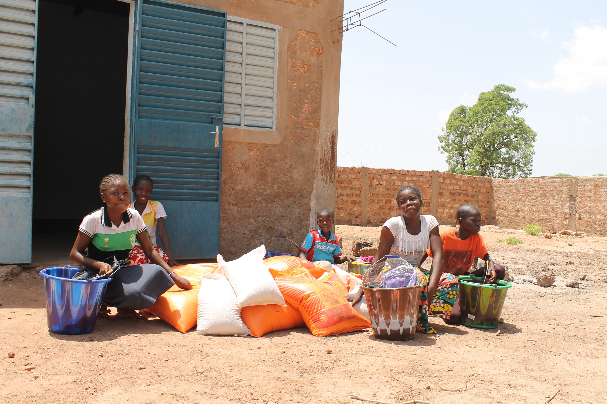 internally displaced women and children receive essential food items like rice and beans in Nouna, Burkina Faso