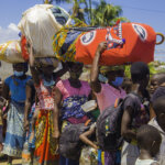 Women and children in Mozambique holding on to their goods