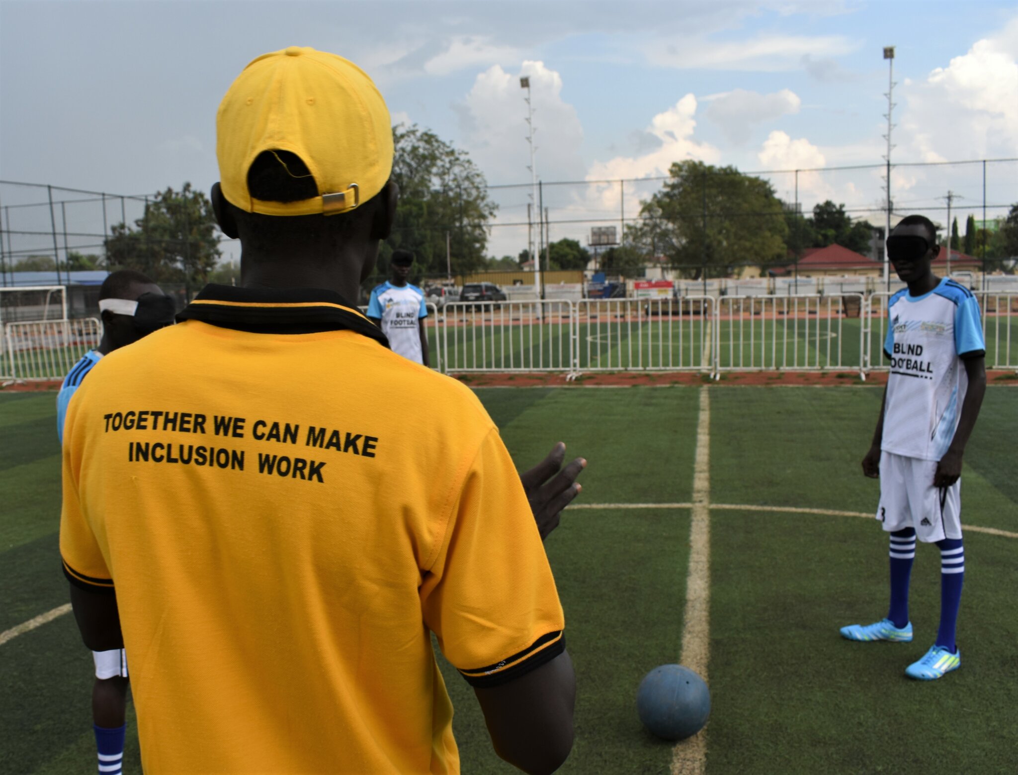 Football coach wearing a 'Together we can make inclusion work' t-shirt, with the blind football team in Juba, South Sudan