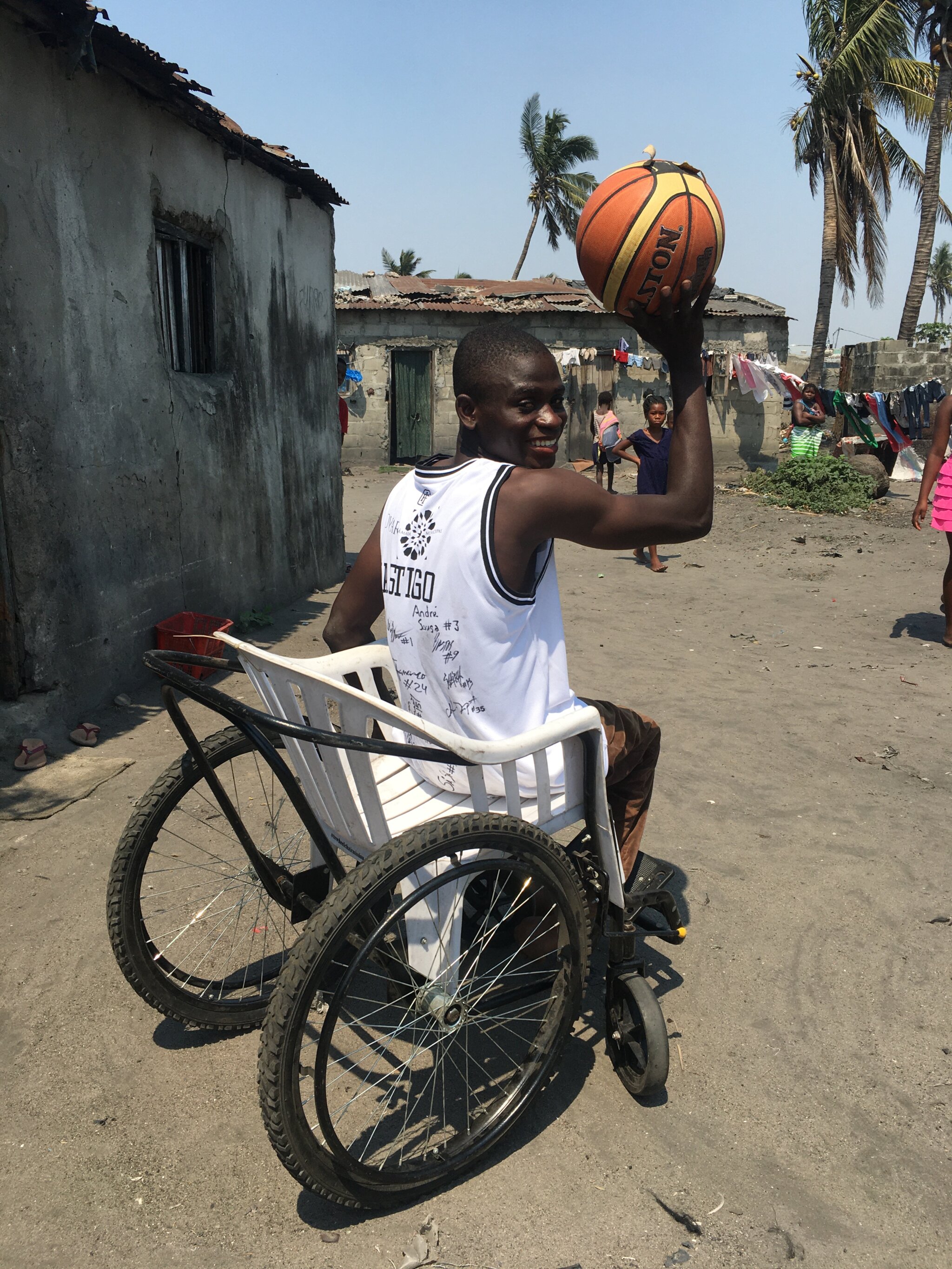 Castigo sits in a wheelchair and gets ready to throw a basketball.