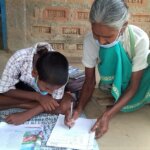 Ten year-old Naresh reading and writing with his grandmother