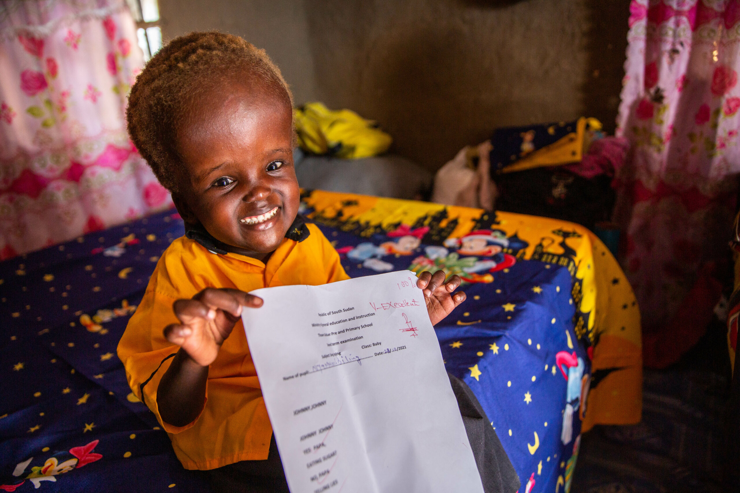 Four year-old Nyamush holds up her class test