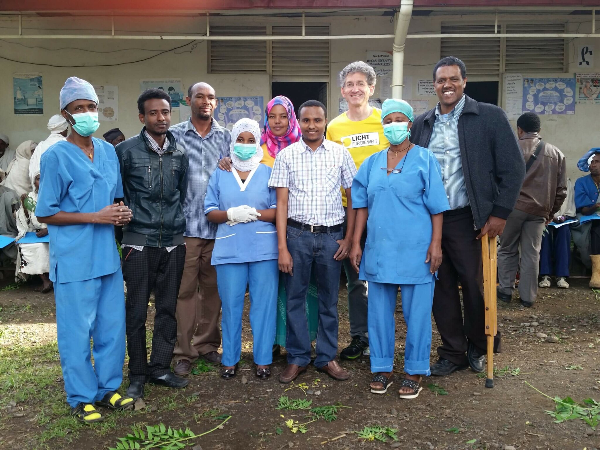 Health workers in Ethiopia stand and smile with Rupert.
