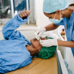 A patient has their eye examined by a doctor