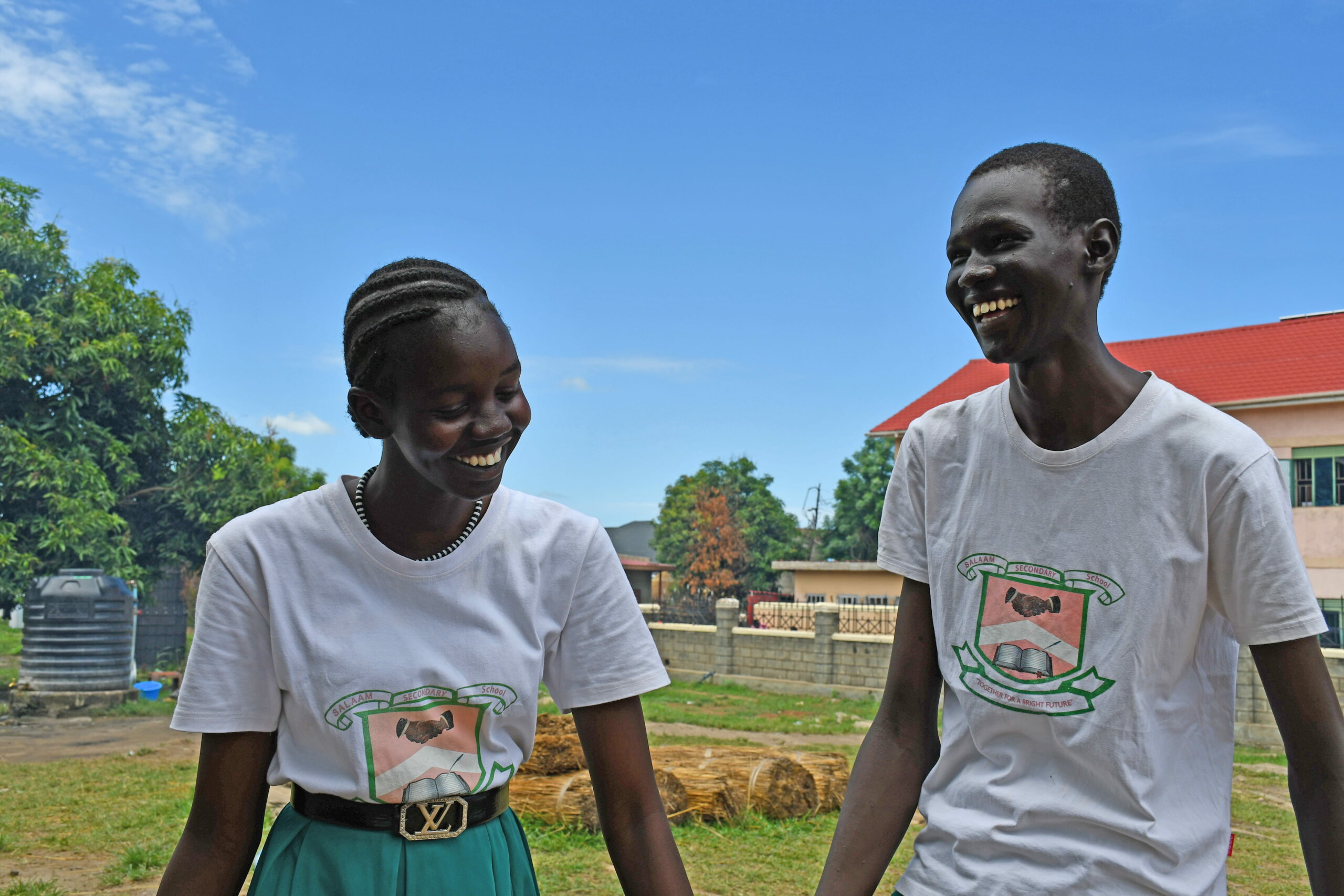 Two South Sudanese pupils smile as they pose for a photo outside their school. South Sudan signing the UNCRPD was one of the positive news stories of 2023.