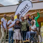 Several people, including Light for the World staff stand in front of a Light for the World banner smiling to celebrate the launch of We Can Work, one of the good news stories of 2023.