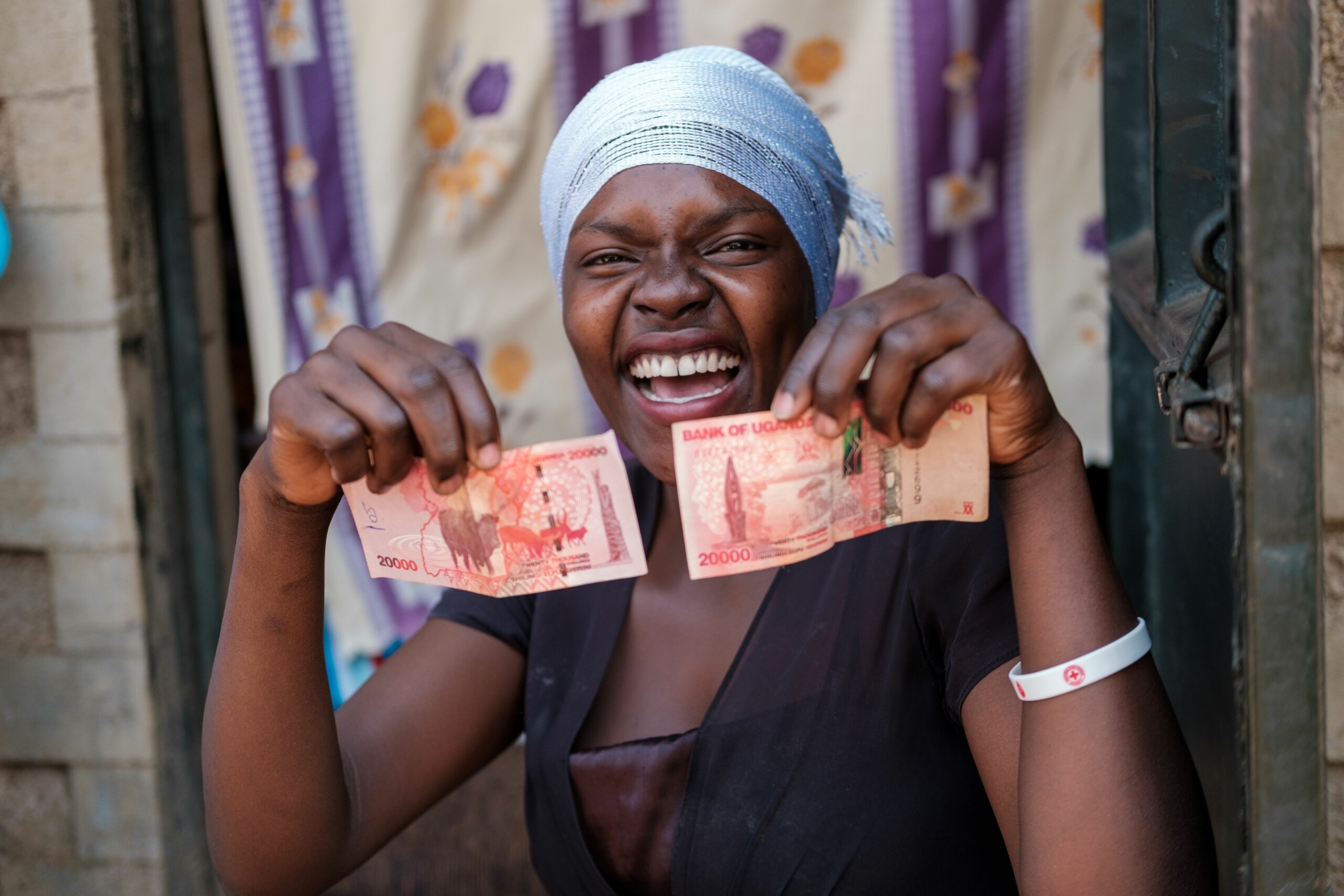 Image of one of the participants in the project: Overcoming Barriers to Food Security: A photo narrative by people with disabilities. She is holding banknotes and smiling.