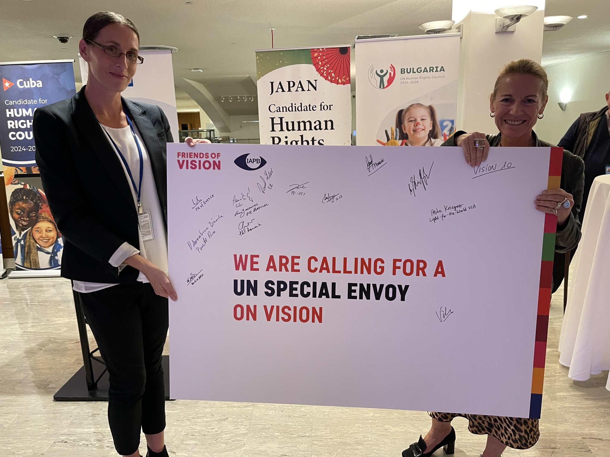 Two women are holding a sign saying 