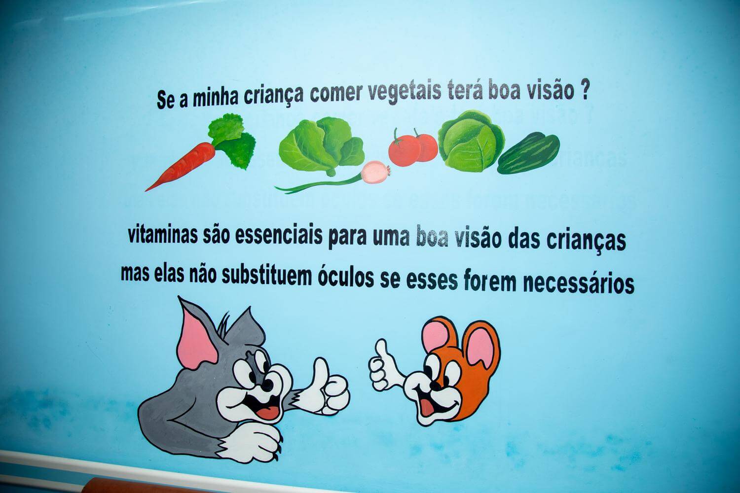 Image of a wall at the eye clinic at Quelimane Central Hospital to raise awareness of child eye health in Mozambique. This wall advises vitamins are essential for good vision in children.