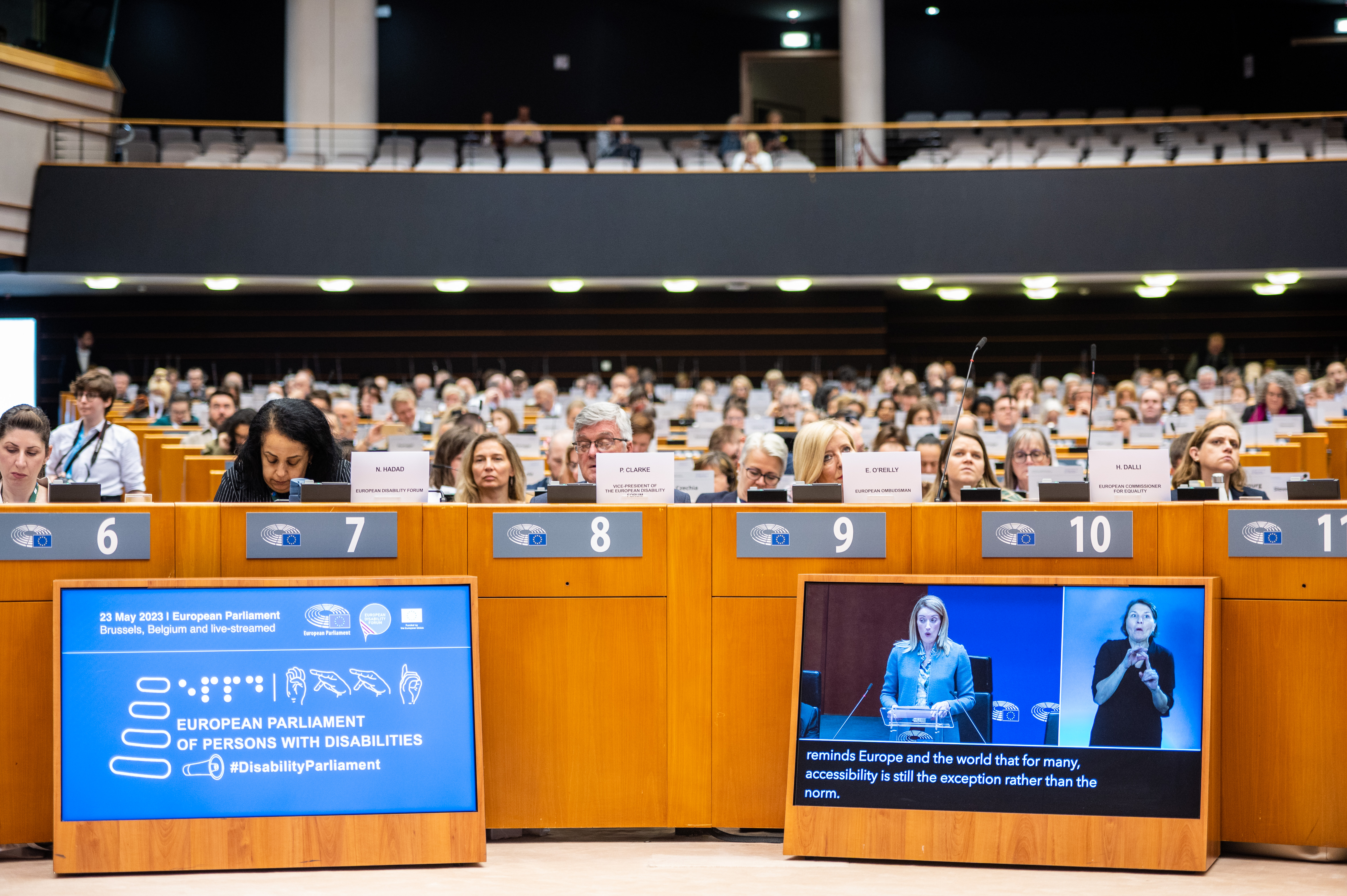 Hundreds of people ist in the EDF conference room. Participants are watching a speech, and we can see sign language interpretation on the screen.