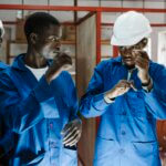 At the Young Africa training center in Beira, Mozambique, Joaquim, a male trainee in metalwork and welding, can be seen on the right wearing a white hard hat and signing.