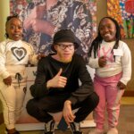 Three young people with disabilities participating in the first workshops of the We Can Work Programme. They are posing for a photo. The man in the middle gives a 