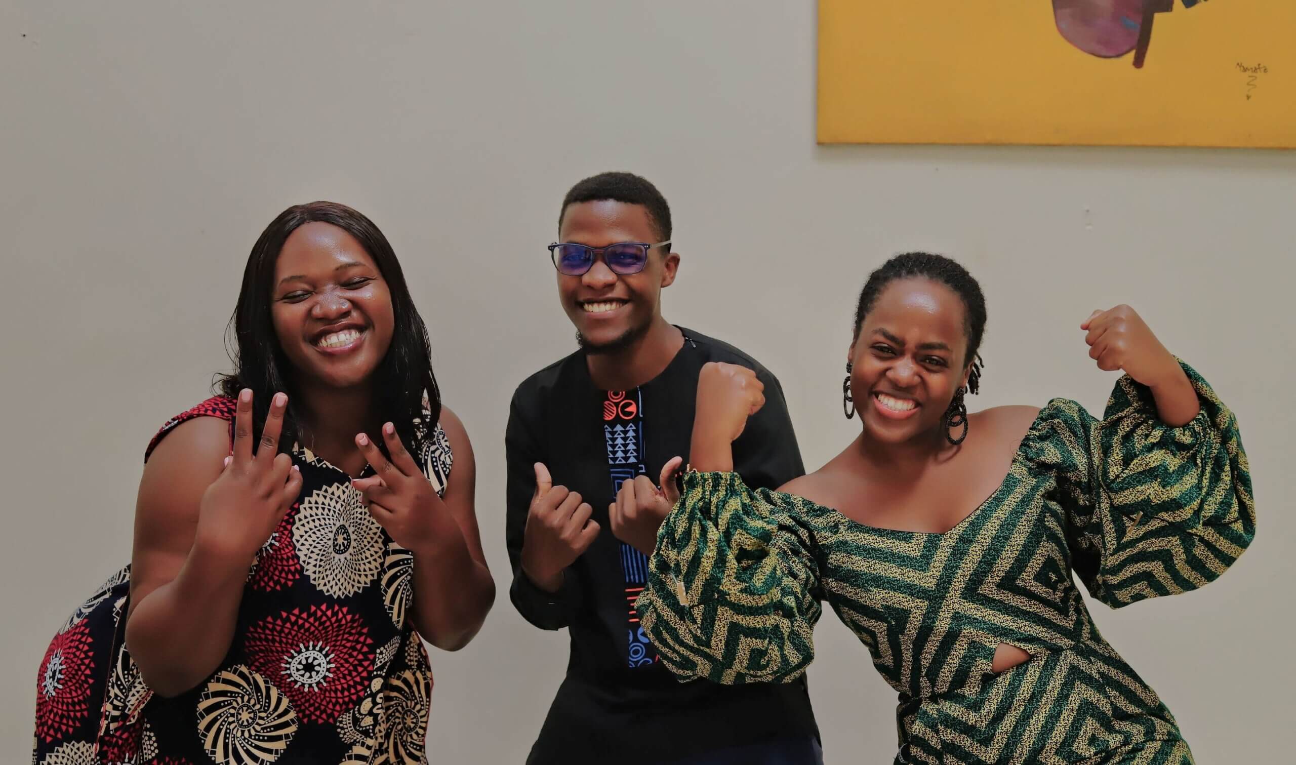 The winners of the We Can Work Storytelling competition in Uganda. On the left is Dr Rachael Kalinaki, in the middle Doreck Ankunda and on the right is Isaac Muhumuza. All three are dressed in bright colours and smiling.