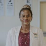 Dr Rebecca Lusobya is a paediatric ophthalmologist at Mulago National Referral Hospital in Kampala, Uganda. She wears a white doctor's coat and is lookng at the camera.