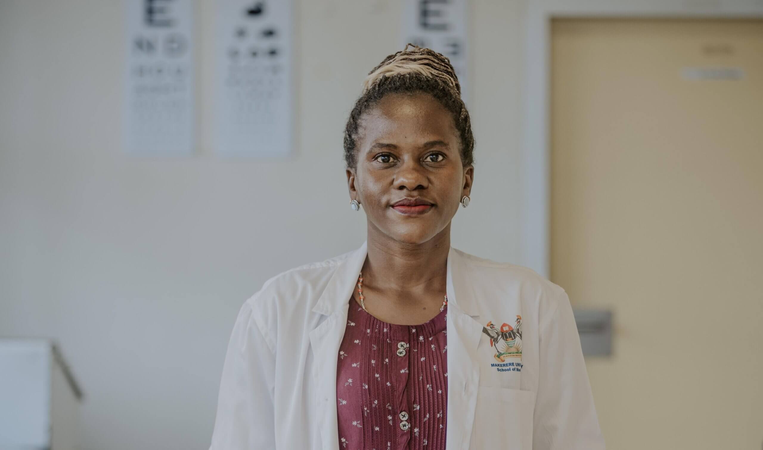 Dr Rebecca Lusobya is a paediatric ophthalmologist at Mulago National Referral Hospital in Kampala, Uganda. She wears a white doctor's coat and is lookng at the camera.