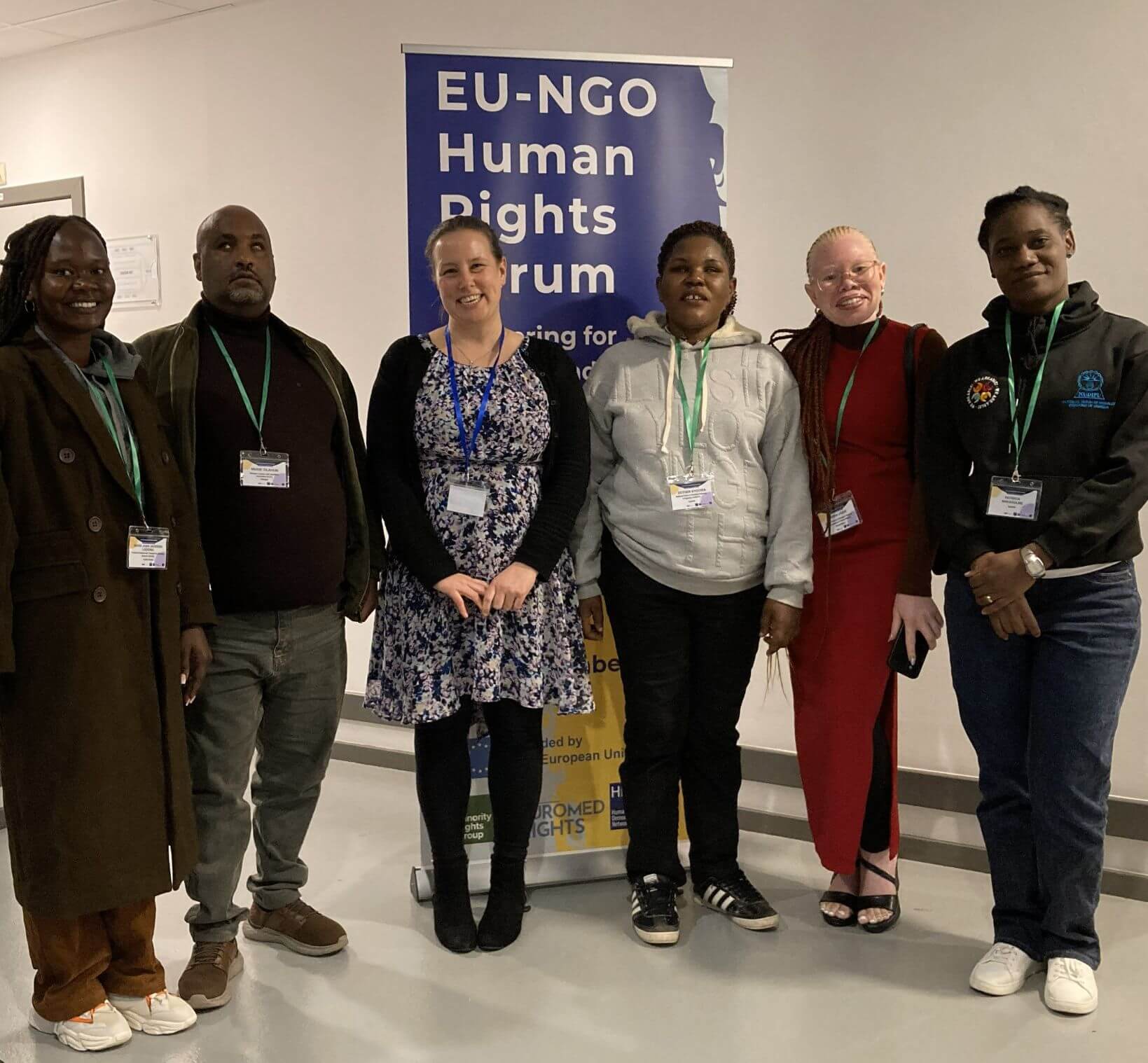 Participants of the EU-NGO Human Rights Forum – Partnering for equality and non-discrimination stand in front of a banner promoting the event. 
